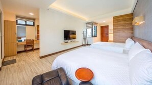 A hotel room with a large bed, a desk, a television, and a view of the outside. - Taitung Yipin Garden Bed and Breakfast (Taitung)