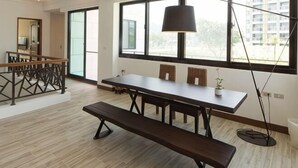 A modern dining area with a long table, benches, and large windows. - Taitung Yipin Garden Bed and Breakfast (Taitung)