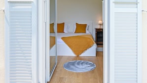 A bedroom with a bed, pillows, a nightstand, and a lamp. - Luxury Central Suite Garden in Lugano (Lugano)