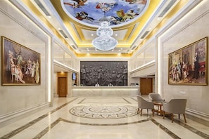 A lobby with a grand chandelier, a reception desk, and classical paintings on the walls. - Vienna Hotel (Nanjing)