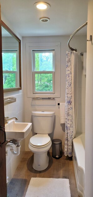 Une salle de bain avec des toilettes, un lavabo et une douche.