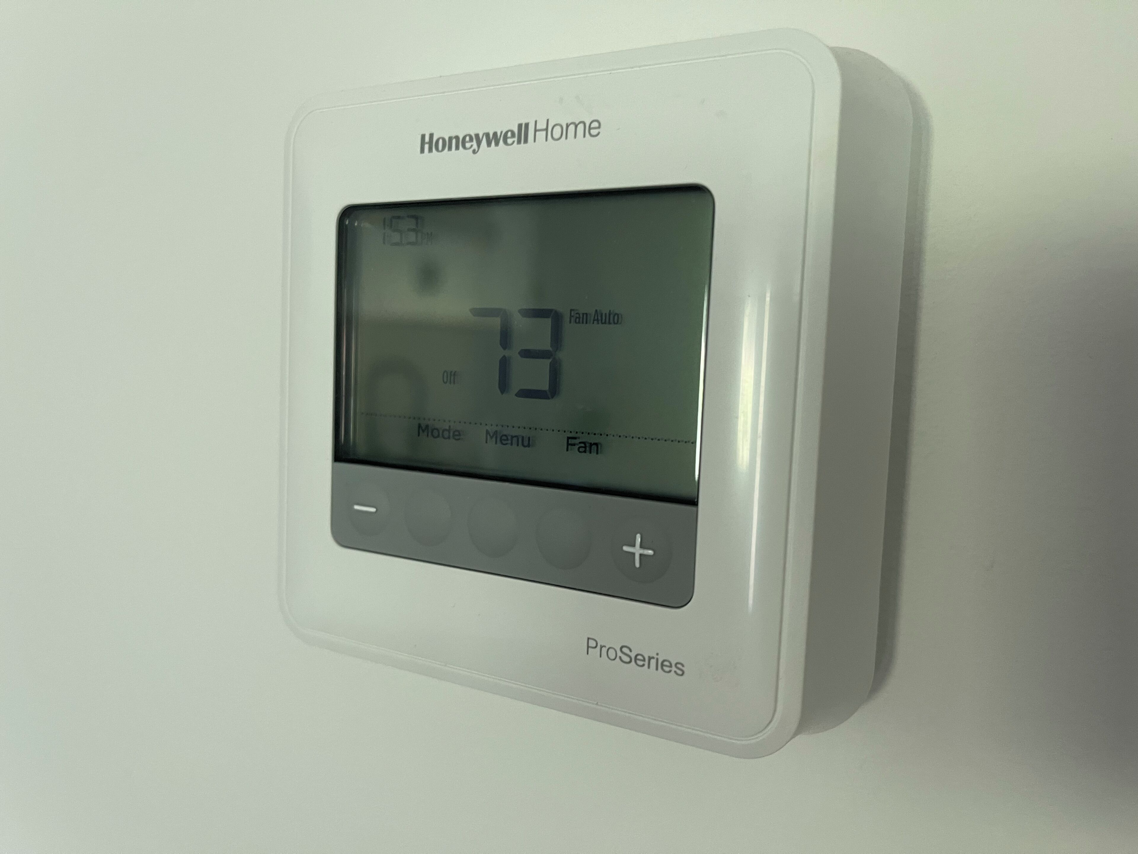 Un thermostat de la gamme Honeywell Home ProSeries fixé au mur.