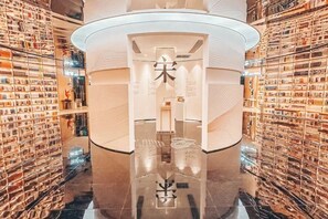 A modern interior with a central circular structure, reflective floor, and patterned walls. - ECHIC Hotel (Shenzhen East Railway Station Buji Subway Station Branch) (Shenzhen)
