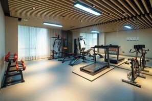 A gym with exercise equipment, large windows, and a modern ceiling design. - ECHIC Hotel (Shenzhen East Railway Station Buji Subway Station Branch) (Shenzhen)