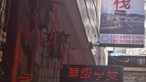 A traditional Chinese building with a signboard displaying contact numbers.
