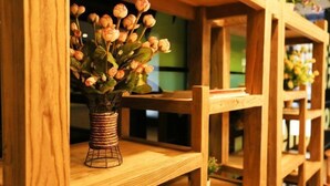 Una estantería de madera con un jarrón de flores.