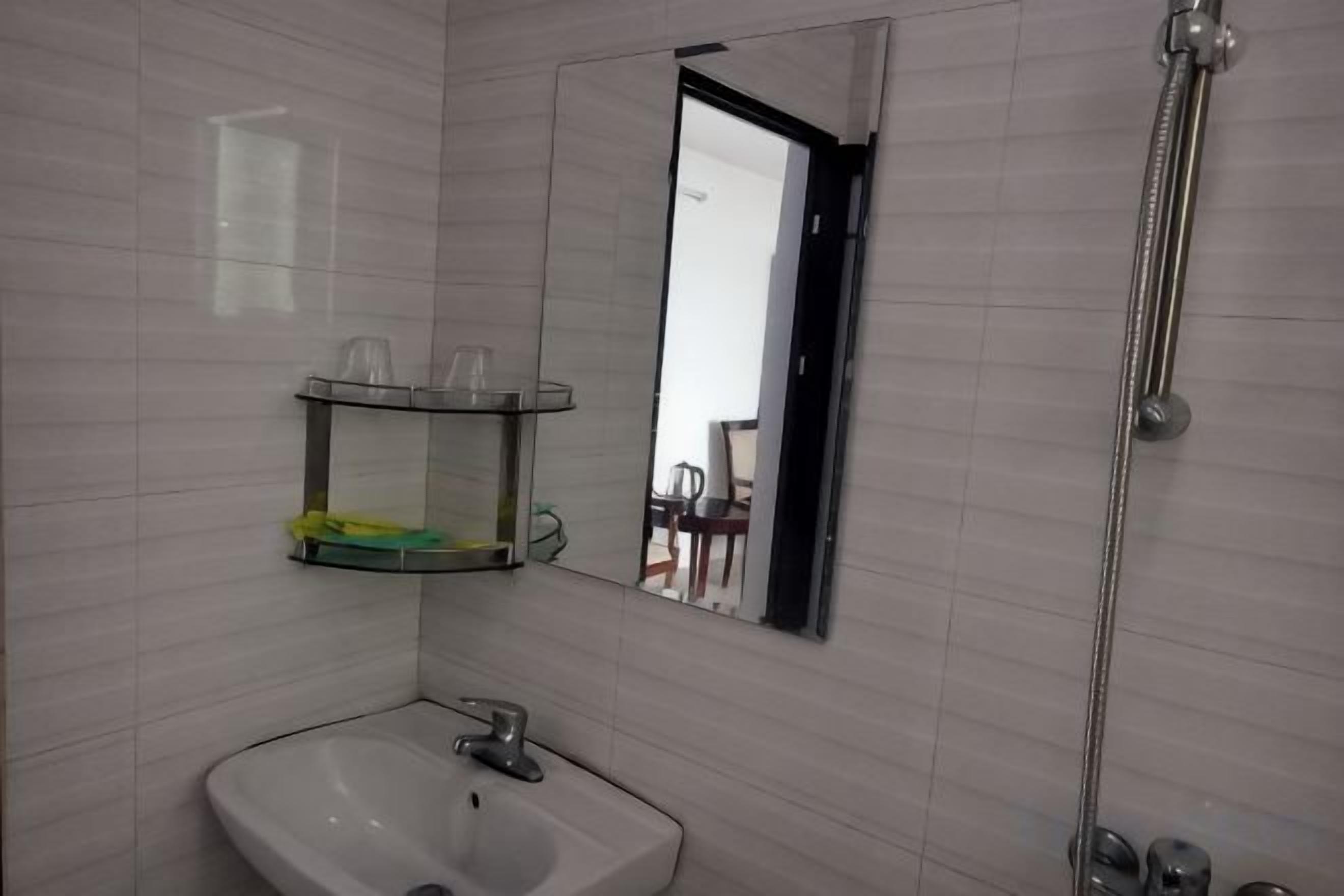 A bathroom with a sink, mirror, and shower.