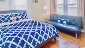 A bedroom with a bed, a sofa, and a window. - **Riverview cottage** perfect for family vacation (Niagara Falls)