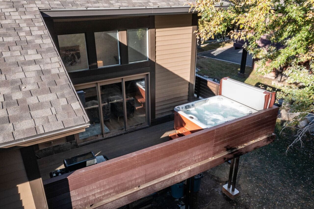 A modern house with a hot tub on the deck.