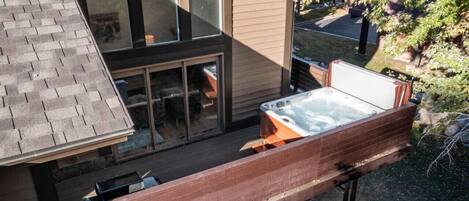 A modern house with a hot tub on the deck.