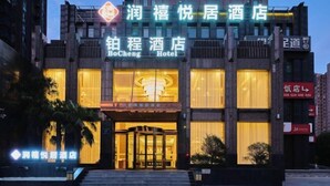 A hotel with a prominent entrance, a large illuminated sign, and a modern facade. - Runxi Yueju Hotel (Zhengzhou Erqi Wanda Plaza) (Zhengzhou)