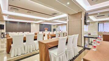 A conference room with tables and chairs, a television, and a large screen.