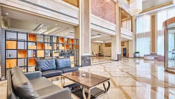 A spacious lobby with a seating area, a coffee table, and a bookshelf.