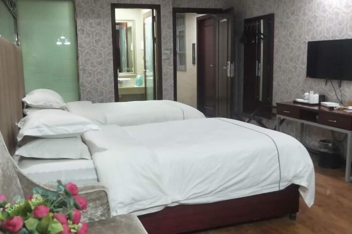 A hotel room with a bed, a desk, a mirror, and a television.