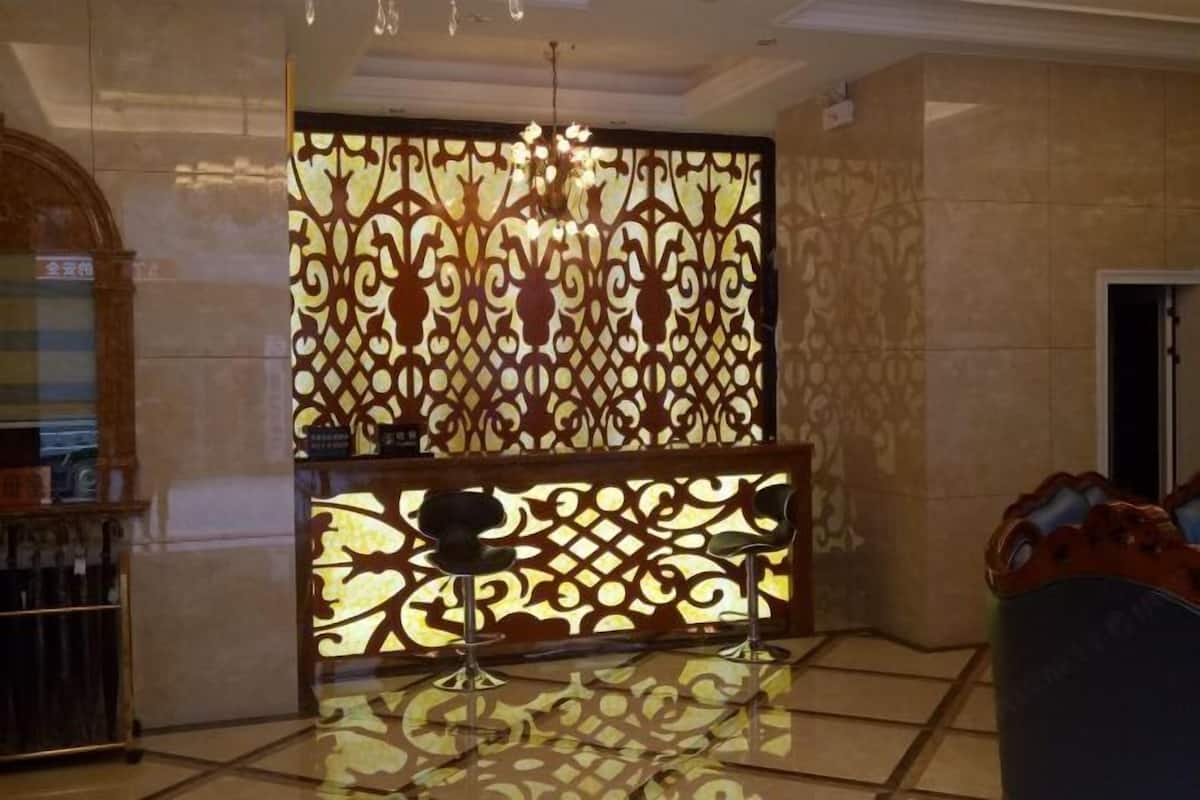 A reception area with a decorative partition, a chandelier, and a seating area with chairs.