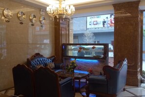 A lobby with a chandelier, a large screen displaying a scene, and a seating area with chairs and a sofa. - Hefeng Pingjing Homestay (Hefeng)