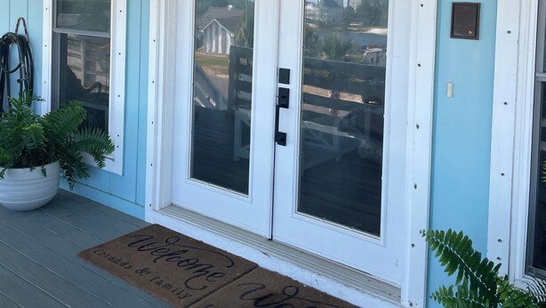 A front door with a sign reading "BEACH HOUSE" above it. - Perdido Key Water View with Pool, Second Floor Duplex (Pensacola)