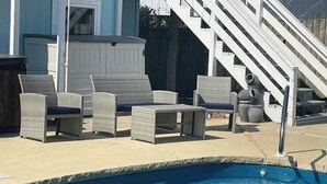 A pool area with wicker furniture and a staircase. - Perdido Key Water View with Pool, Second Floor Duplex (Pensacola)