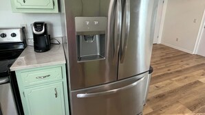 A kitchen with a stainless steel refrigerator, a coffee maker, and a microwave. - Perdido Key Water View with Pool, Second Floor Duplex (Pensacola)