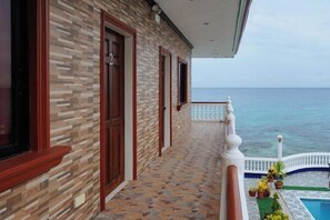 A building with a tiled balcony overlooking a body of water. - RedDoorz Plus @ Billys Resort Oslob (Oslob)