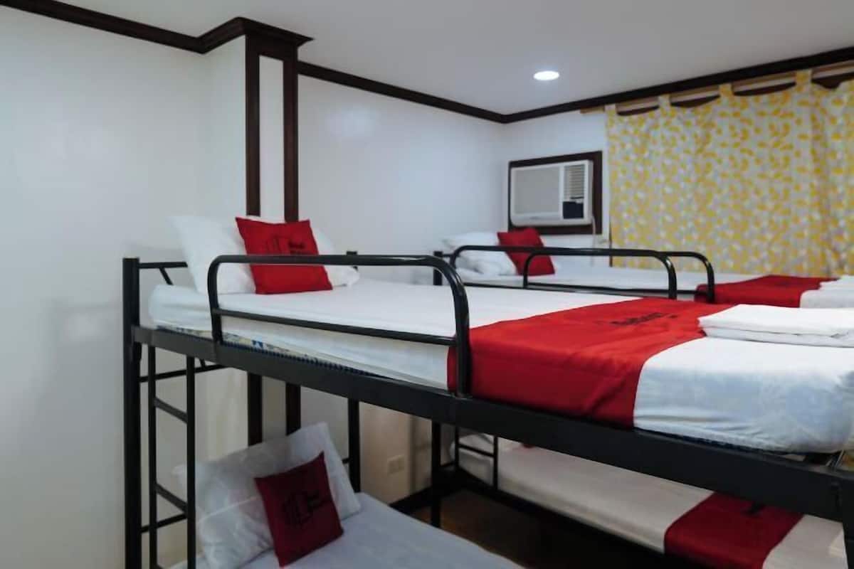 Habitación tipo dormitorio con literas, un espejo y una ventana con cortinas.