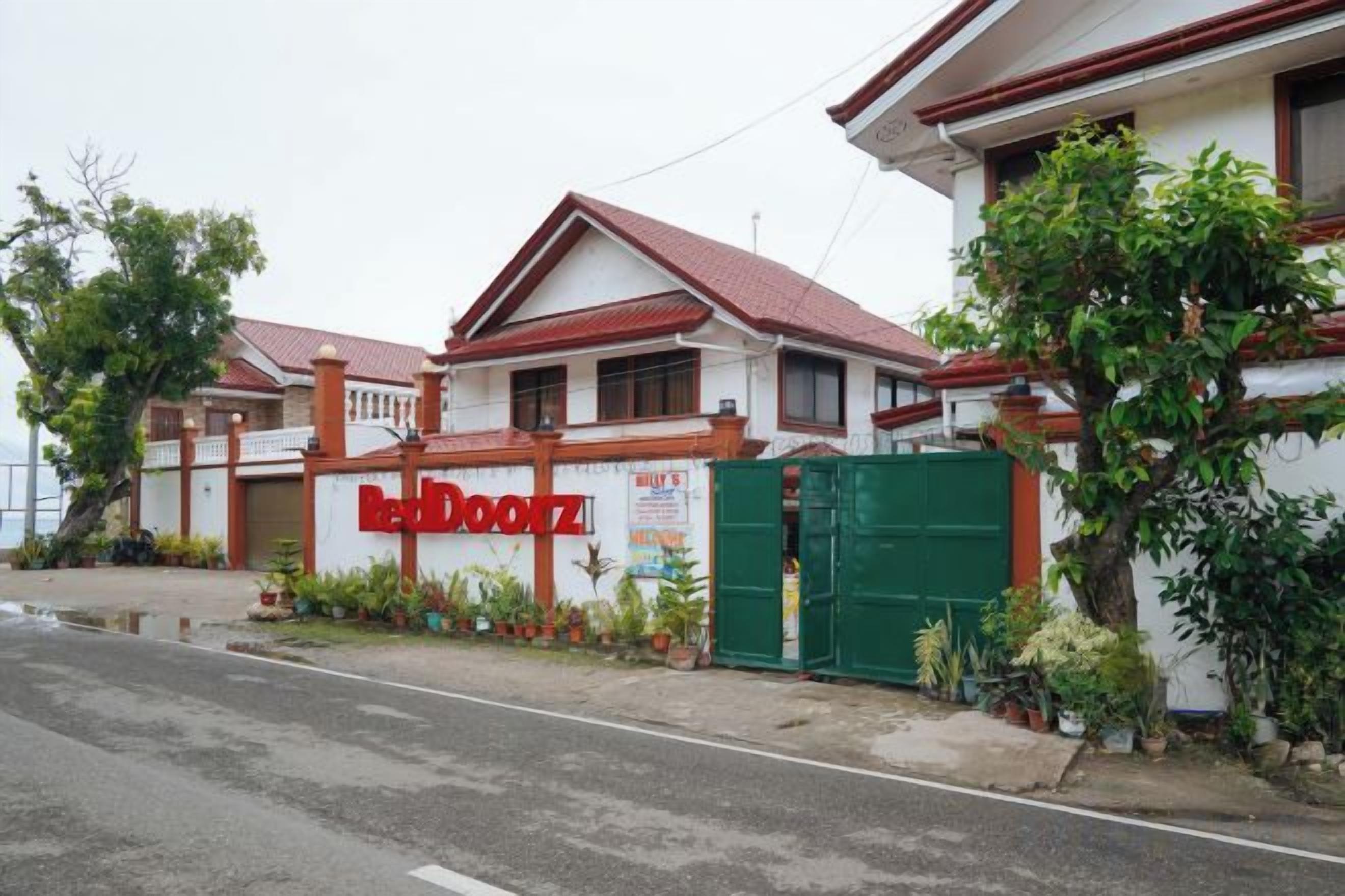A two-story building with a red and white facade, a gated entrance, and a sign that reads 'LaDooz.'