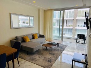 컴포트 아파트, 침대(여러 개), 발코니 | 거실 공간 | 평면 TV