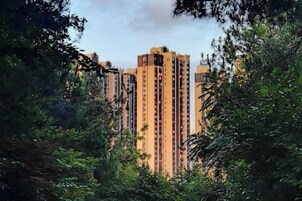 Un edificio alto rodeado de vegetación densa.