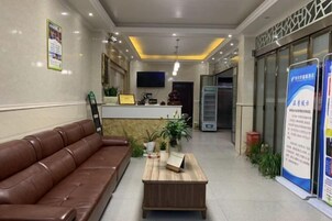 A reception area with a brown leather sofa, a wooden coffee table, and a reception desk.