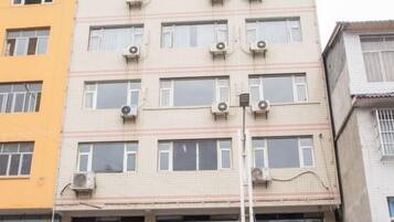 Un edificio de varios pisos con unidades de aire acondicionado en la fachada.