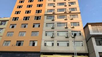 A multi-story building with multiple windows and air conditioning units.