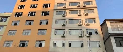 A multi-story building with multiple windows and air conditioning units.