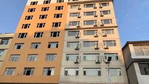 A multi-story building with multiple windows and air conditioning units. - Furui Hotel (Lichuan)