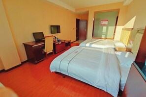 A hotel room with two beds, a desk with a television, and a door with a sign. - Furui Hotel (Lichuan)