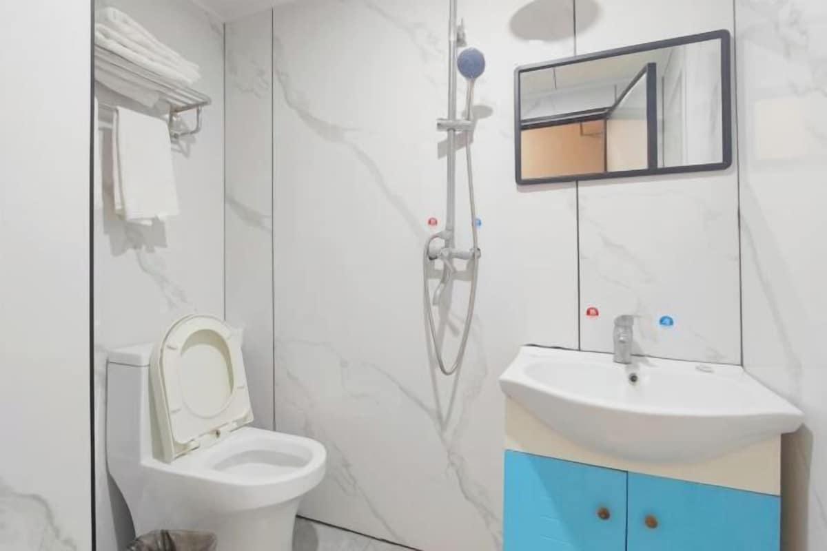 A bathroom with a toilet, a sink, and a shower.