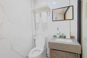 A bathroom with a white toilet, a sink with toiletries, a towel rack, and a mirror. - Yaju Homestay Hotel (Zunyi Conference Site) (Zunyi)