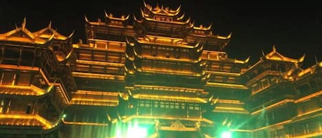 A multi-tiered traditional building with illuminated architectural details.