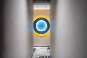 A corridor with a circular light fixture on the wall, a carpeted floor, and a door at the end. - Yaju Homestay Hotel (Zunyi Conference Site) (Zunyi)