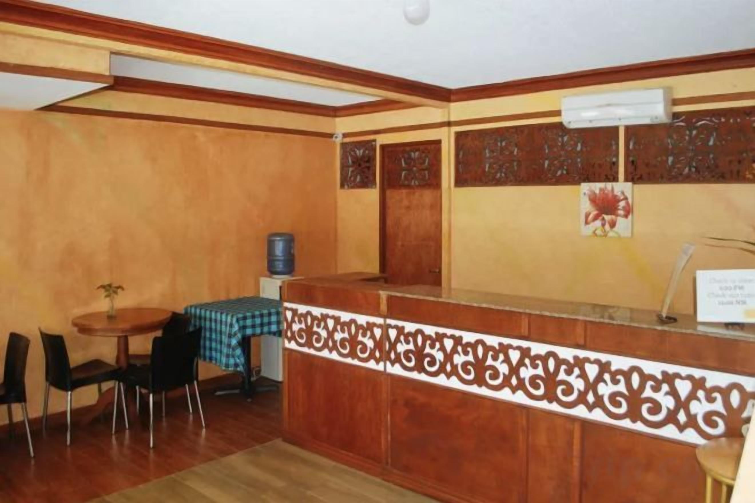 A reception area with a wooden reception desk, a checkered tablecloth, and a water dispenser.