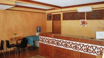 A reception area with a wooden reception desk, a checkered tablecloth, and a water dispenser.