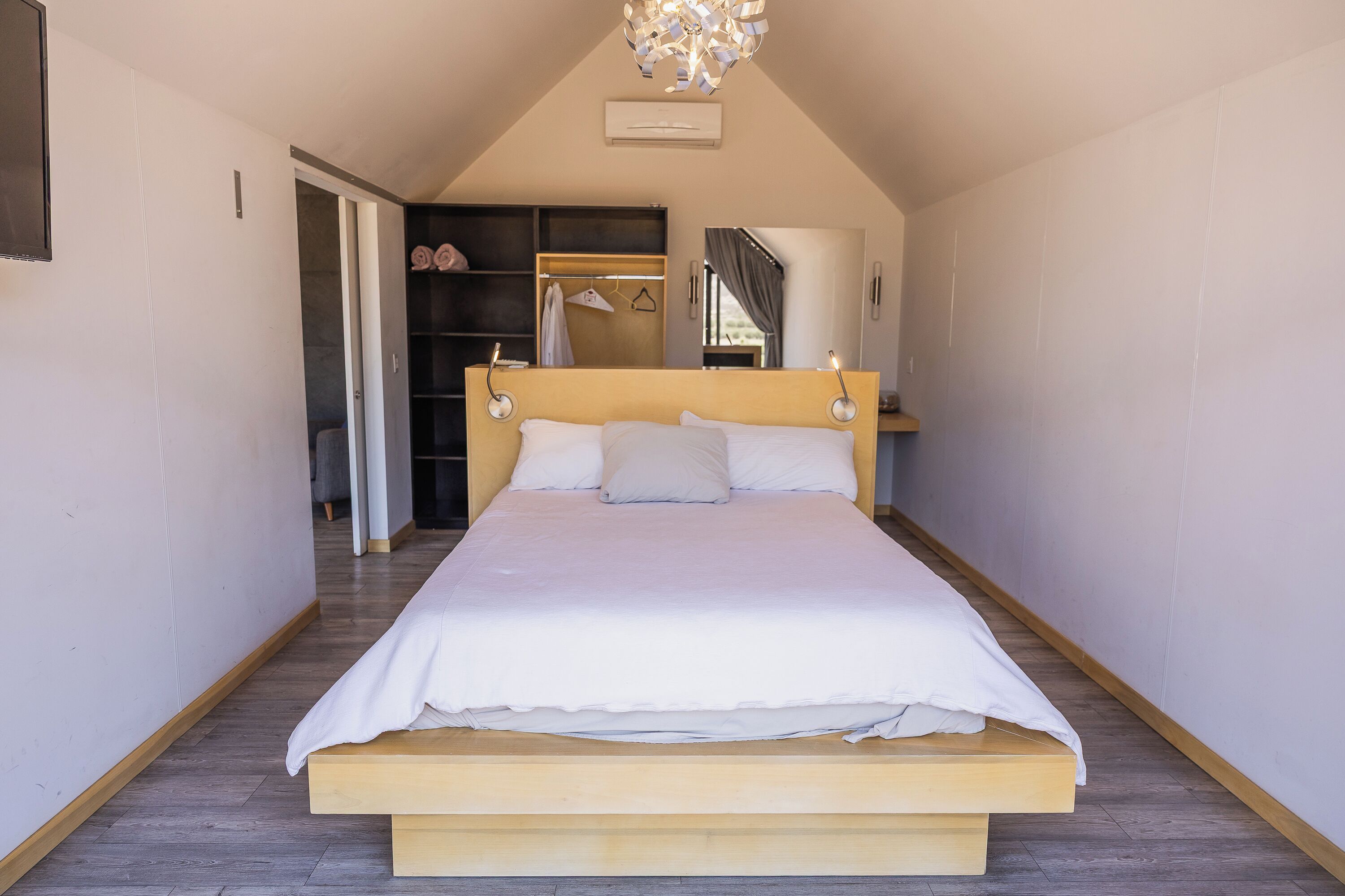 Un dormitorio con una cama grande, un armario y un espejo.