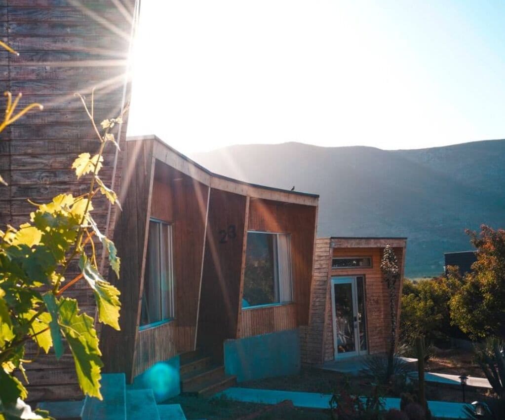 Una casa moderna con techo curvo, ventanas amplias y una puerta pequeña.