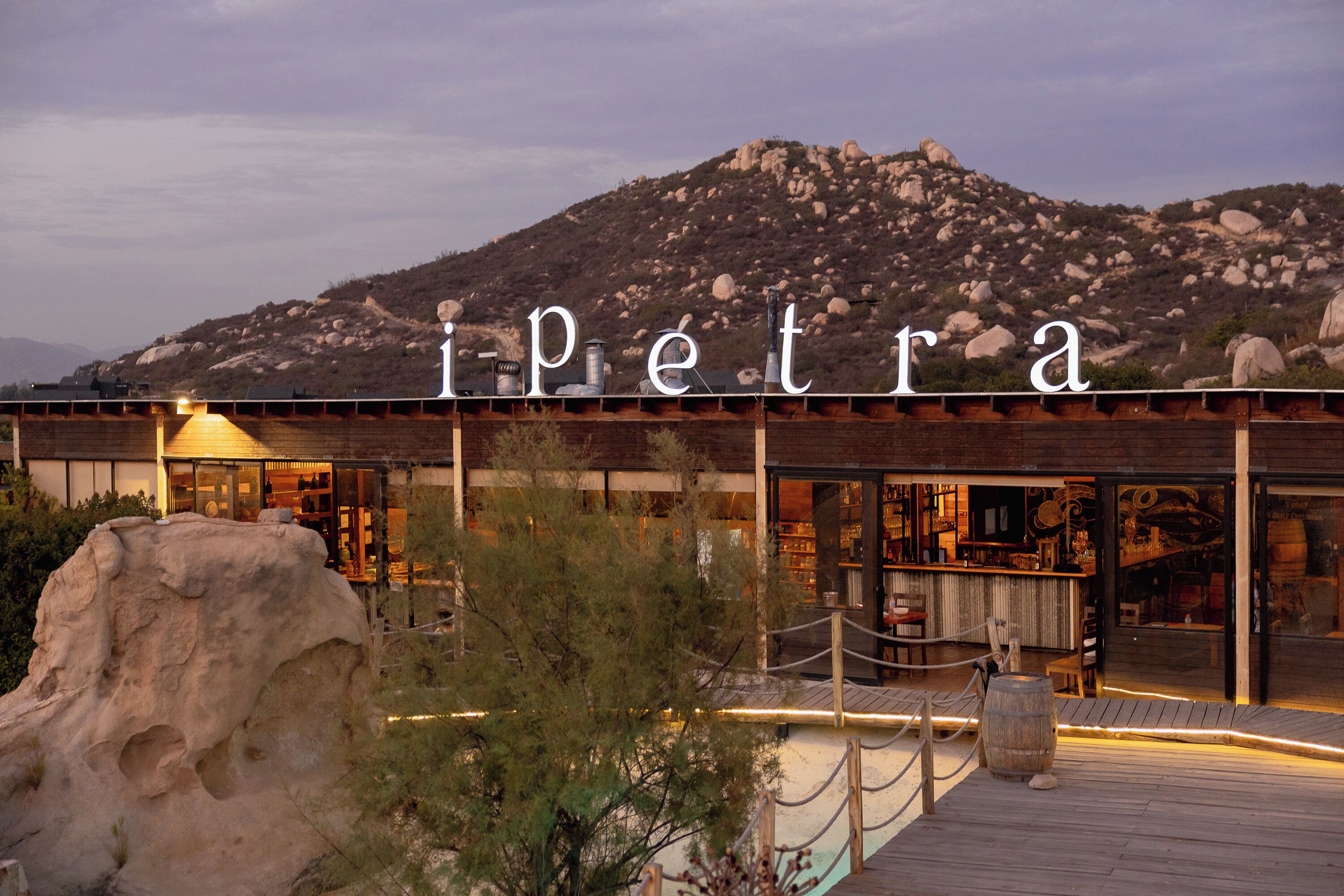 A hotel with a prominent name sign 'ipetra' and a wooden deck area.