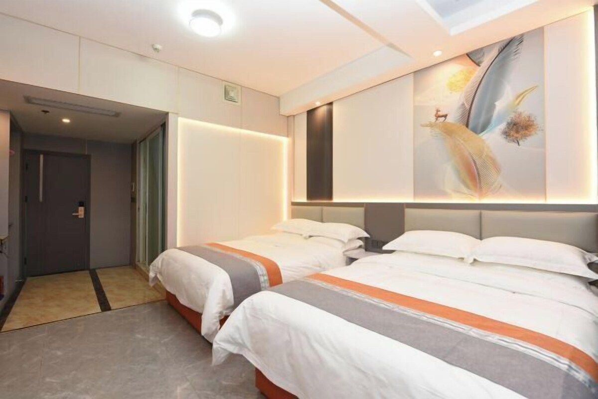 A hotel room with two beds, a large painting on the wall, and a door leading to another room.