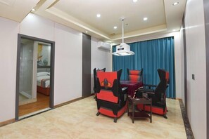 A hotel room with a bed, a desk, and a chair. There is a window with blue curtains and a ceiling light. - Junyu Hotel (Guangdong Women's Vocational and Technical College Asian Games Village Branch) (Guangzhou)