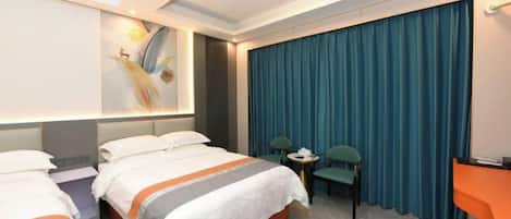 A hotel room with a bed, a desk, a chair, and a curtain.