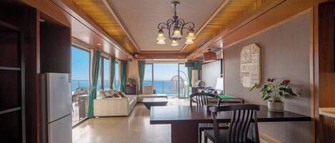 Una cocina moderna con zona de comedor, ventanas amplias y vista al mar.