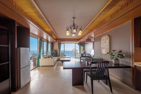 A modern kitchen with a dining area, large windows, and a view of the sea. - Xunliao Bay Yijing Holiday Sea-view Hotel (Huidong)
