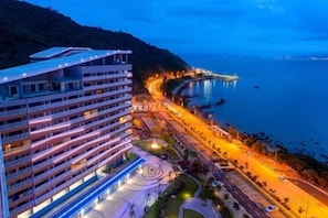 A coastal hotel with multiple floors, a parking area, and a view of the sea. - Xunliao Bay Yijing Holiday Sea-view Hotel (Huidong)