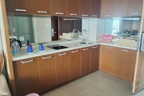 A compact kitchen with wooden cabinets, a sink, and a countertop. - Xunliao Bay Yijing Holiday Sea-view Hotel (Huidong)